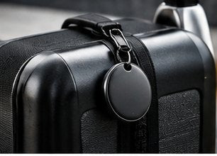TECHSAFE Tag clipped to the strap of a hard-shell suitcase.
